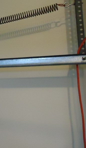 Extension spring hooked at the end of the horizontal track